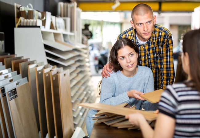 Competent,Seller,Consulting,Young,Couple,About,Purchase,Of,Laminate,Flooring
